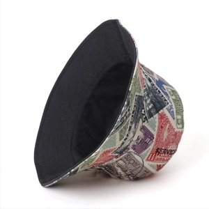 Reversible bucket hat with vintage stamp prints and solid black side for outdoor sun protection