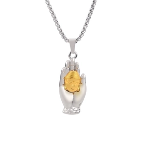 Silver hand holding golden Buddha head pendant necklace on a silver box chain