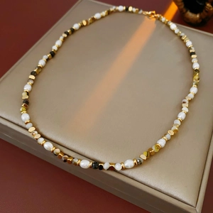Detailed close-up of freshwater pearls and dark gemstone beads on a premium leather surface