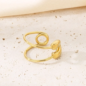 Detail of creative gold safety pin ring design with a polished finish on stone background