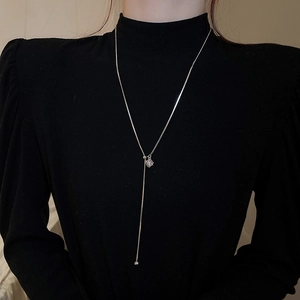 Silver Y-necklace detail with sparkling snowflake pendant and adjustable metal ball drop