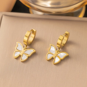Elegant gold butterfly hoop earrings with white shell inlay on a luxury display box
