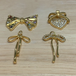 Detailed view of micro-pave zircon bow and crown pendants for DIY jewelry making