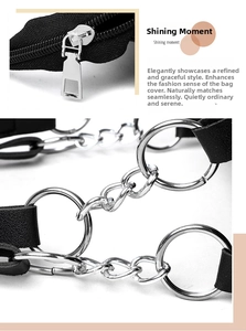Detail of silver metal zipper and chain links on a black tote bag's handle attachment