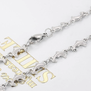 Macro shot of silver dolphin-shaped steel links with tiny sparkling embedded crystals