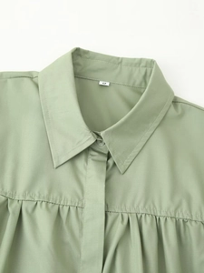 Close-up of bean green shirt collar featuring crisp pleats and woven fabric texture