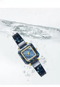 Wasserdichte Quarzuhr aus blauem Marmor mit goldenen Zeigern in klarem Wasser gespritzt