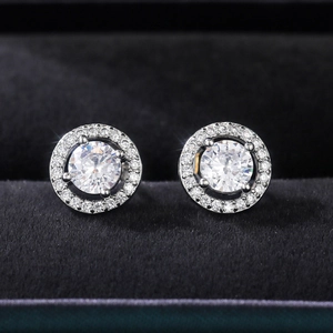 Macro shot of silver zircon flower stud earrings displayed on a black velvet jewelry box