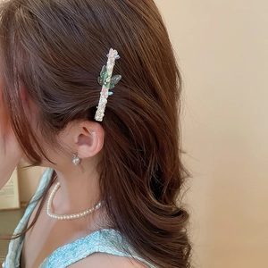 Détail d'une pince à cheveux papillon élégante avec perles et strass portée de côté