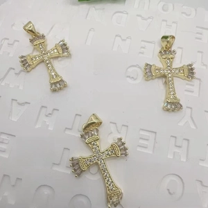 Detailed close-up of 18K gold-plated cross pendants with white zircon and engravings