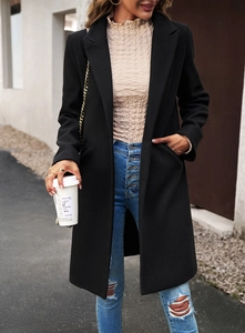 Street style view of a black mid-length wool coat with casual jeans and trendy urban look