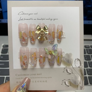 Detail of pink jelly press-on nails with 3D metallic bow and aurora butterfly charms