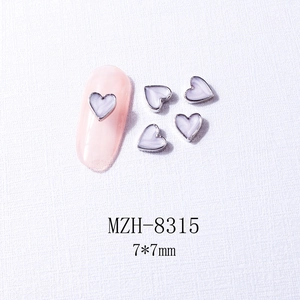 Detailed view of silver heart nail charms with white gradient center and sizing markers