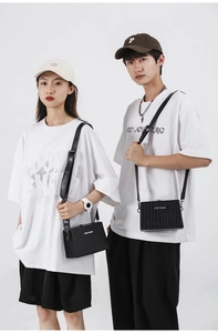 Close-up of unisex black box bag featuring crocodile texture and white logo branding