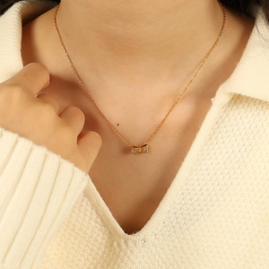 Collier élégant avec pendentif nœud doré serti de diamants blancs en acier titane