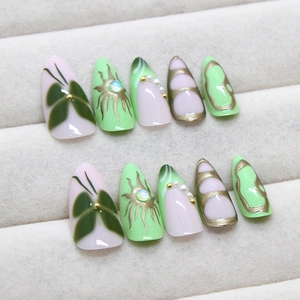 Green butterfly almond press-on nails with 3D pearls and gold details in a display box