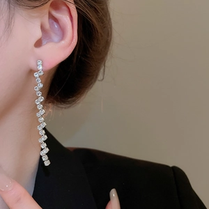 Detailed view of silver tassel earrings with zircon stones on a model, elegant drape style