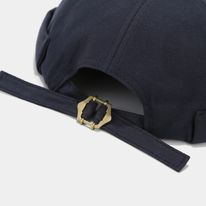 Detail of navy blue cotton docker hat featuring an adjustable vintage metal buckle