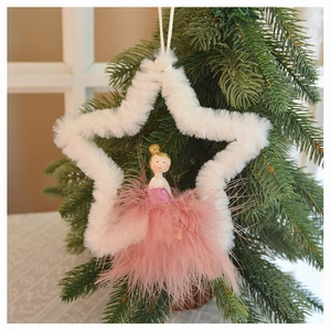 Detail of plush star ornament with fairy in pink feathers hanging on a Christmas tree