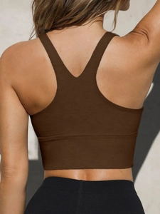 Close-up of dark brown racerback sports bra with wide underbust band for yoga support
