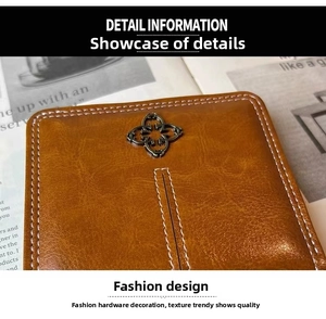 Detail of brown litchi pattern leather wallet with vintage bronze flower ornament