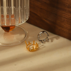 Artistic gold and silver lava crown rings displayed on beige velvet with warm lighting