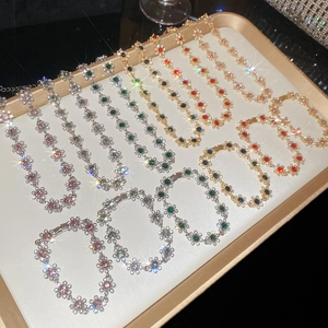 Flat lay of floral diamond pendants and bracelets in assorted vibrant gemstone colors