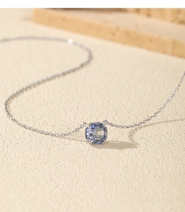 Detail of S925 sterling silver necklace featuring a square blue tanzanite stone pendant