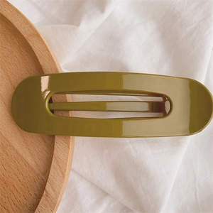 Detail of a large olive green hair clip with a glossy finish and hollow rectangular design