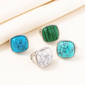 Macro detail of adjustable silver rings featuring colorful square malachite and turquoise stones