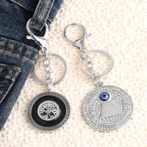 Blue Evil Eye and Tree of Life keychain with sparkling rhinestones on denim background