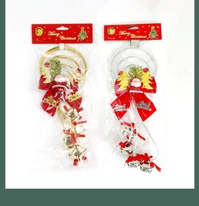 Detail of gold and silver Christmas bell ornaments with red bows and Santa Claus figures