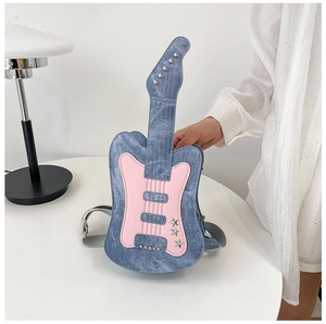 Detail view of the guitar-shaped denim crossbody bag with pink patches and silver star rivets