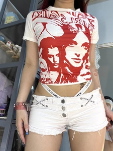 Nahaufnahme von weißem Crop-Top mit rotem Grafikprint und ausgefransten Denim-Hotpants