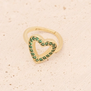 Macro shot of gold-plated hollow heart ring with pave-set green crystals on stone