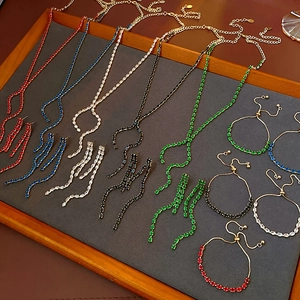 Detailed flat lay of luxury jewelry sets with teardrop zircons in multiple vibrant colors