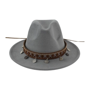 Detail view of the ethnic woven band and metallic coin charms on grey felt fedora