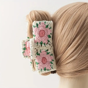 Detail of crochet knit hair claw with pink flower and green leaves on cream base