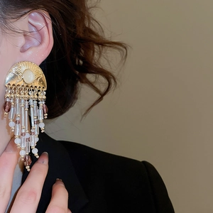 Detail of luxury vintage tassel earrings with pearls and purple crystal drops on model