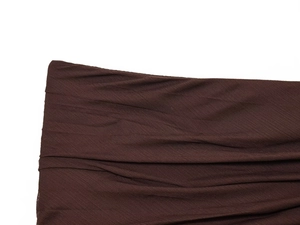 Close-up detail of dark brown translucent pleated fabric with fine diagonal textures