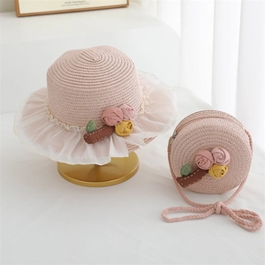 Detailed view of pink woven straw hat and matching round crossbody bag with lace trim