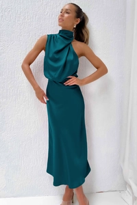 Detail of elegant dark green satin dress featuring a cowl neck halter and draped fabric
