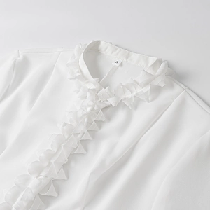 Close-up of ruffled standing collar and front detail on a white chiffon shirt