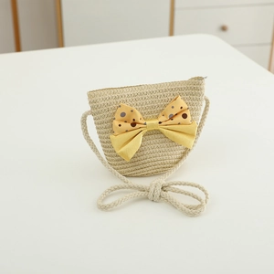 Detail of kids straw crossbody bag with a yellow polka dot bow and rope strap