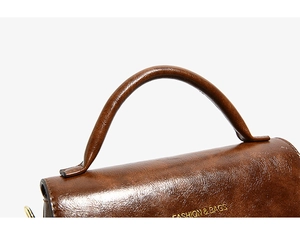 Dettagli di una borsa vintage in pelle cerata marrone con manico e patta elegante