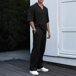 Men's black short sleeve polo and matching trousers set with vertical knit texture