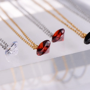 Sparkling heart-shaped diamond pendant necklaces in red, black, and white gold finishes