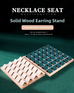 Macro shot of wooden earring display stands with beige and dark green leather triangle studs