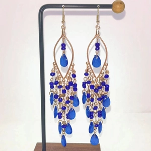 Bohemian long tassel earrings with blue beads and crystals on a display stand