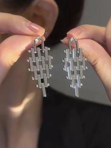 Detail shot of silver geometric interlocking metal trapezoid earrings with high polish finish